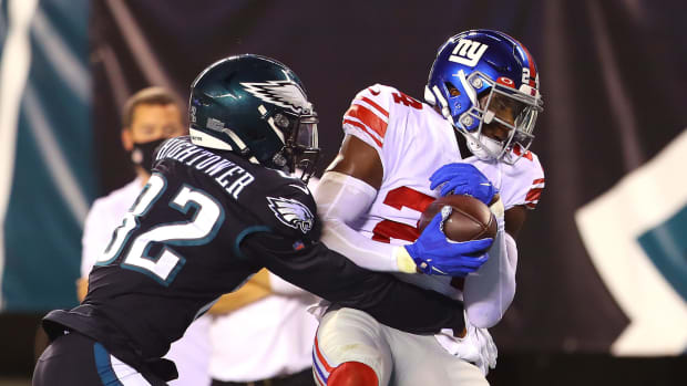 Giants player James Bradberry grabs the ball away from an Eagles player.