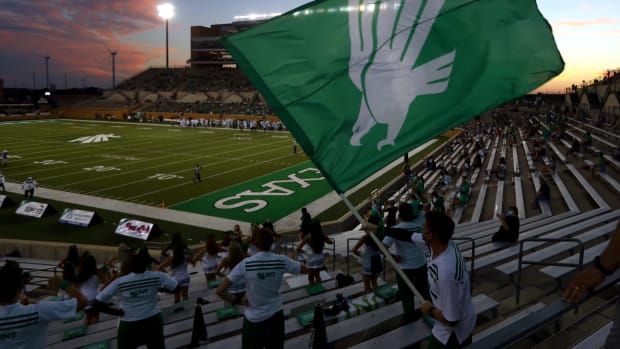 A North Texas fan waves a flag during the Mean Green college football game to open the 2020 season.