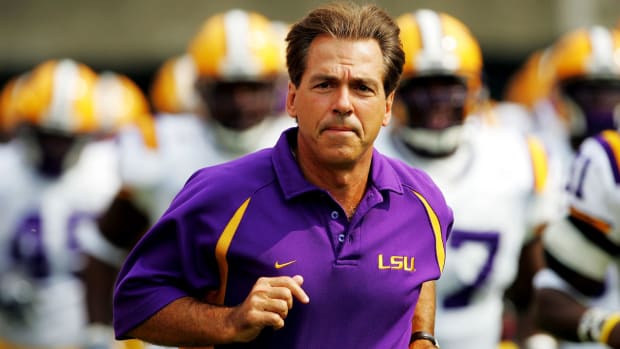 Nick Saban jogs onto the field before an LSU game.