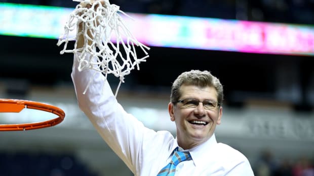 Geno Auriemma holding the net after cutting it down.
