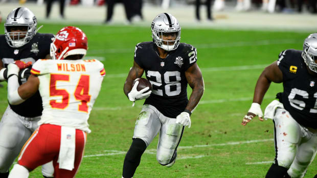 Josh Jacobs runs with the ball for the Raiders.