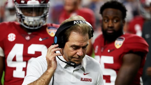 A closeup of Alabama football coach Nick Saban speaking into his headset.