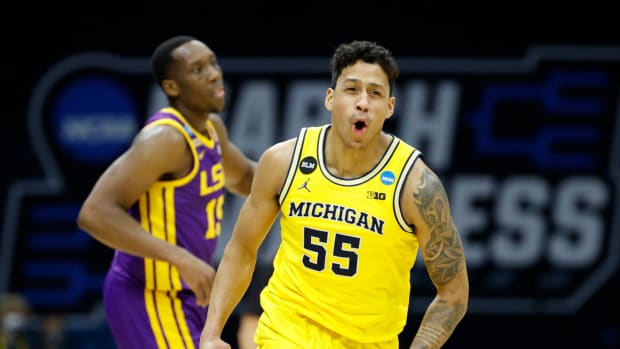 Eli Brooks #55 of the Michigan Wolverines reacts to making a three