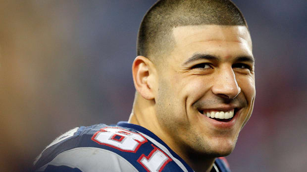 aaron hernandez smiles on the field during a game against the patriots