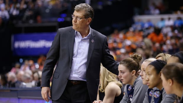 Geno Auriemma patting one of his players on the back.
