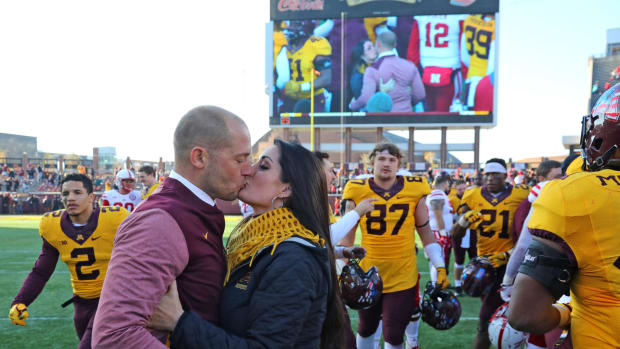 PJ Fleck and his wife kiss.