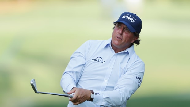 Phil Mickelson looking at his shot as it flies through the air.