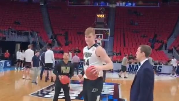 isaac haas dribbling a basketball with a brace on.