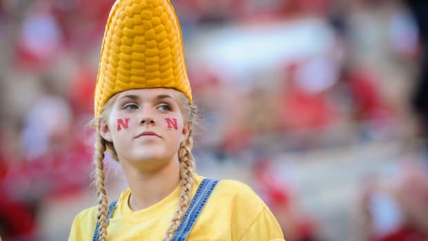 Nebraska fan with a husk of corn on her head.