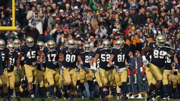 Notre Dame's football players running onto the field.