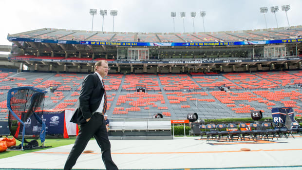 Gus Malzahn walking in an empty stadium.