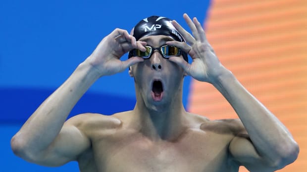 Michael Phelps adjusting his goggles.