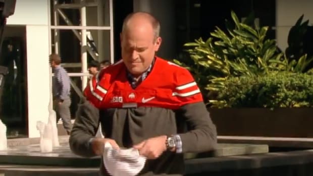 Rich Eisen putting on an Ohio State jersey after losing a bet.