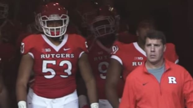 Rutgers players walk out of tunnel onto field.