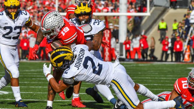 Michigan's Will Johnson tackles an Ohio State player running with the ball.