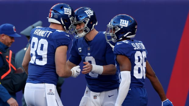 EAST RUTHERFORD, NEW JERSEY - JANUARY 01: Daniel Jones #8 of the New York Giants is congratulated by teammates after scoring a touchdown against the Indianapolis Colts during the third quarter at MetLife Stadium on January 01, 2023 in East Rutherford, New Jersey. (Photo by Jamie Squire/Getty Images)