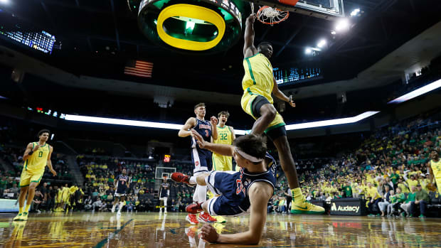 EUGENE, OREGON - JANUARY 14: N'Faly Dante #1 of the Oregon Ducks dunks the ball past Kerr Kriisa #25 of the Arizona Wildcats during the first half at Matthew Knight Arena on January 14, 2023 in Eugene, Oregon. (Photo by Soobum Im/Getty Images)
