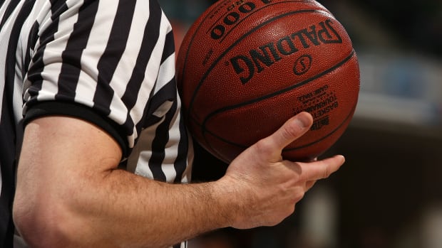 A photo of a referee holding the basketball in the Big Ten.