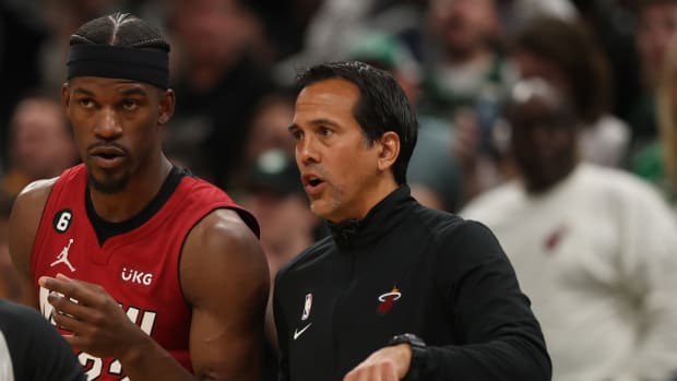 Jimmy Butler talks with Erik Spoelstra during a game.
