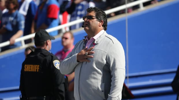 Tony Siragusa stands with his hand over his heart during the national anthem before an NFL game.