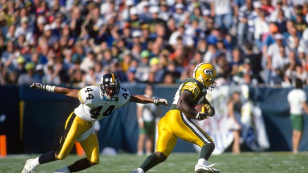 GREEN BAY, WI - SEPTEMBER 27:  Sterling Sharpe #84 of the Green Bay Packers catches a pass in front of D.J. Johnson #44 of the Pittsburgh Steelers during an NFL football game September 27, 1992 at Lambeau Field in Green Bay, Wisconsin. Sharpe played for the Packers from 1988-94. (Photo by Focus on Sport/Getty Images)