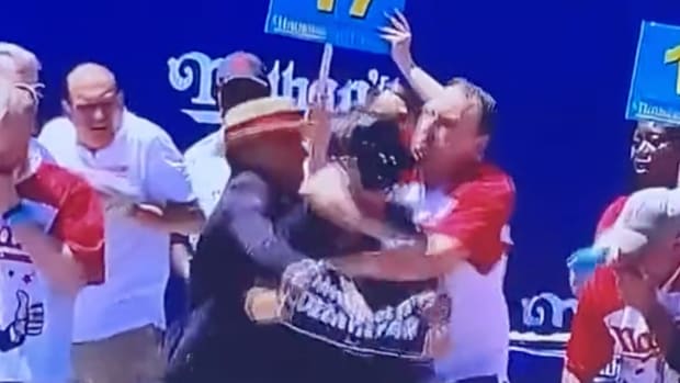 Joey Chestnut takes down protestor during hot dog competition.