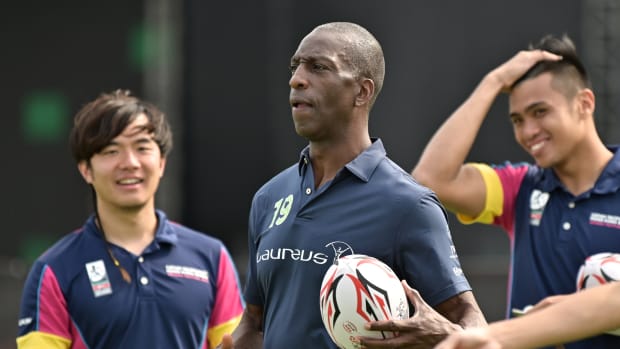 In this photo taken on April 3, 2019, retired US athlete and Olympic gold medalist Michael Johnson (C) attends a promotional event ahead of the Hong Kong Rugby Sevens tournament. - US sprint champion Michael Johnson says he is "back to normal" after he was blindsided by his stroke last year, in a recovery he credits in part to his rewarding years of charity work. Johnson is in Hong Kong for the weekend's Rugby Sevens tournament -- the biggest event on the city's sporting calendar. (Photo by Anthony WALLACE / AFP) / TO GO WITH AFP STORY RUGBY-HKG-ATHLETICS-USA-JOHNSON,INTERVIEW BY SEAN GLEESON        (Photo credit should read ANTHONY WALLACE/AFP via Getty Images)