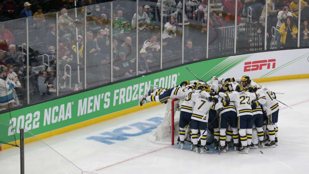 Michigan hockey players huddle in front of the net before a Frozen Four game.