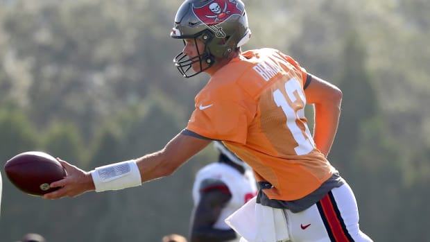 Bucs quarterback Tom Brady goes to hand off the football at training camp in Tampa Bay.