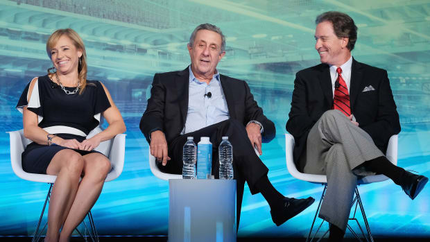 A photo of Stephania Bell, Len Berman and Kevin Harlan on stage at an event.