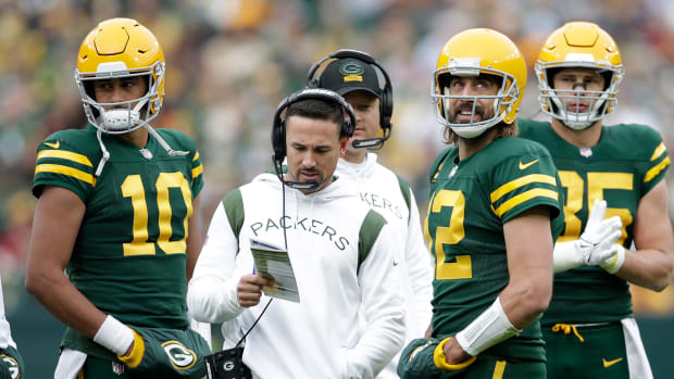 Aaron Rodgers talks with Green Bay Packers head coach Matt LaFleur as Jordan Love listens