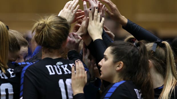 Duke volleyball players on the court before a game.
