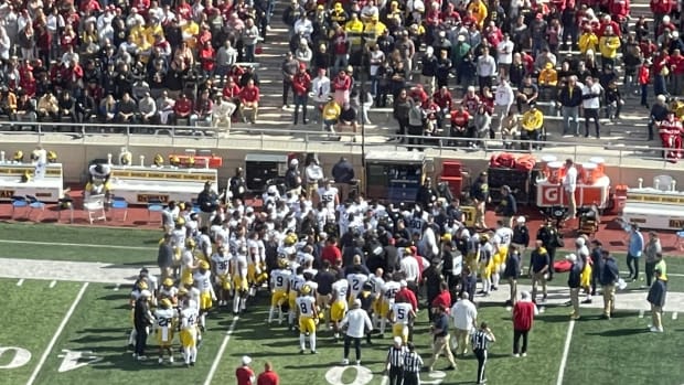 Michigan sideline huddles around assistant coach Mike Hart.