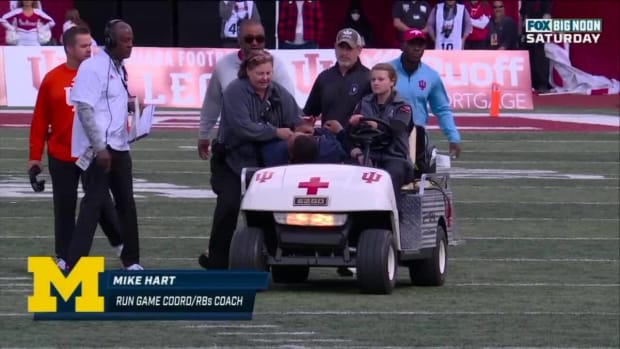 Michigan running backs coach Mike Hart is carted off.