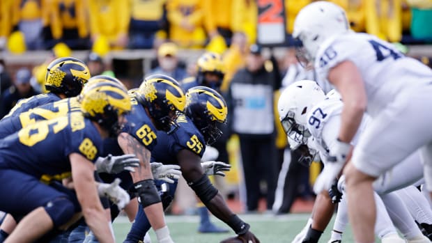 Michigan and Penn State players at the line of scrimmage.