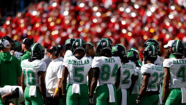 Marshall football players huddling up.