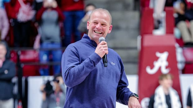 Alabama head football coach Kalen DeBoer speaks to Crimson Tide fans during a basketball game.