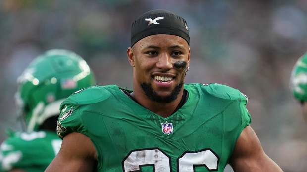 Saquon Barkley smiles on the field during a game.