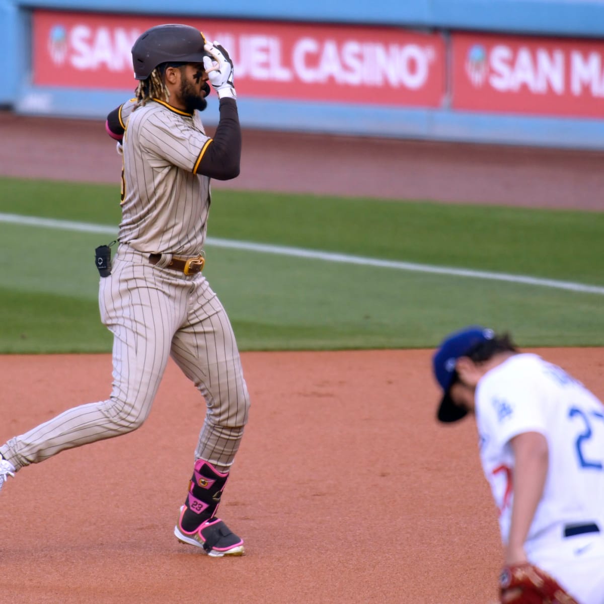 San Diego Padres' Fernando Tatis Jr. wears pink cleats as he stands on  first base after drawing a walk during the first inning of a baseball game  against the San Francisco Giants