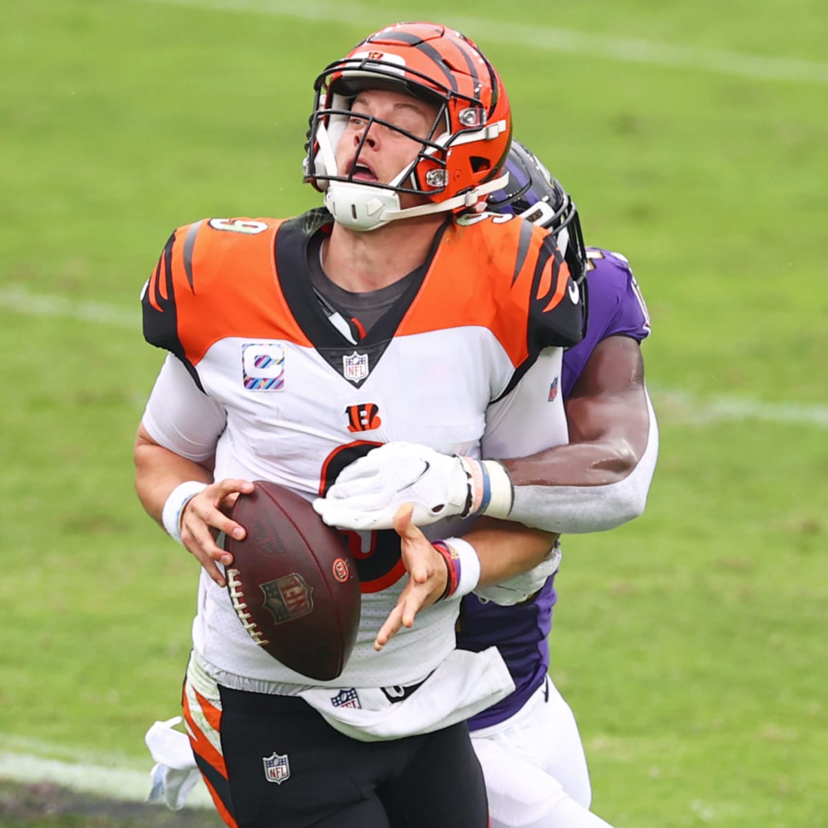 Cincinnati Bengals quarterback Joe Burrow (9) carries the ball against  Baltimore Ravens linebacker Patrick Queen (6) during the first half of an  NFL wild-card football game Sunday, Jan. 15, 2023, in Cincinnati. (