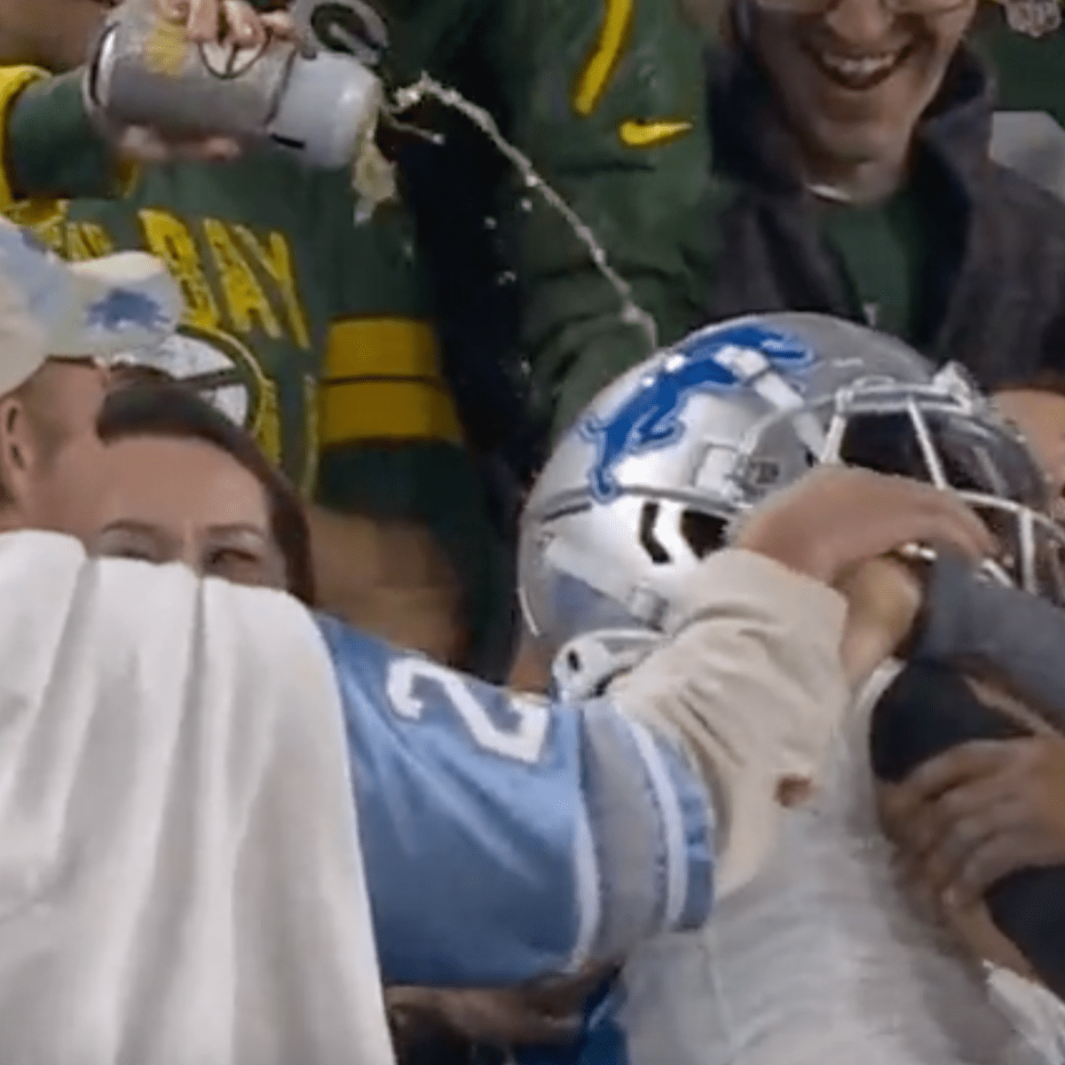 Packers fan dumps beer on Amon-Ra St. Brown after Lambeau Leap