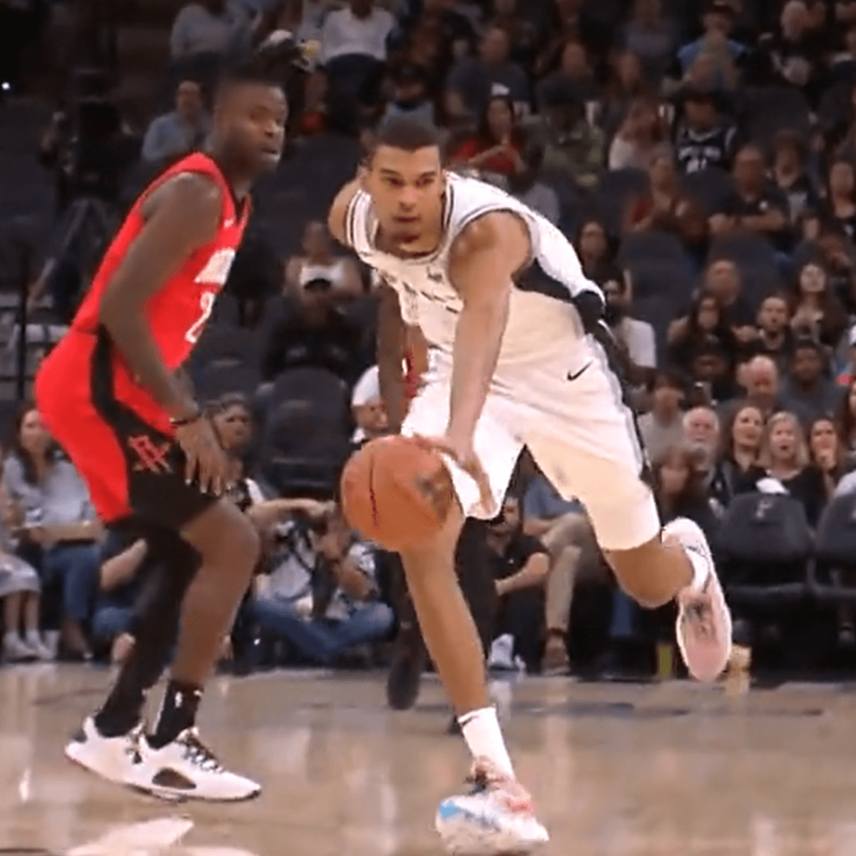 Spurs' Victor Wembanyama dribbling the ball through Reggie