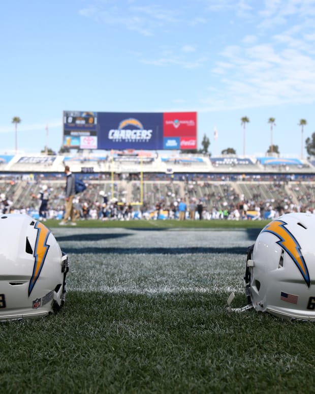 Two Los Angeles Chargers helmets sitting on the field.