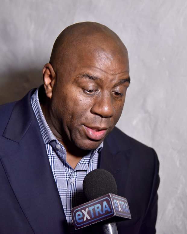 Magic Johnson speaks with reporters at an event.