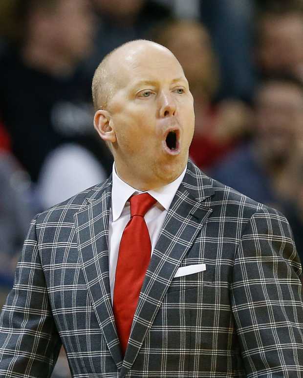 Mick Cronin with his mouth wide open while wearing a red tie.