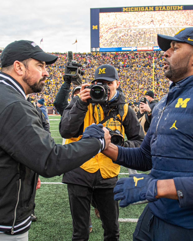 ANN ARBOR, MICHIGAN - NOVEMBER 25: Head Football Coaches Ryan Day (L) of the Ohio State Buckeyes and Sherrone Moore (R) of the Michigan Wolverines shake hands after a college football game at Michigan Stadium on November 25, 2023 in Ann Arbor, Michigan. The Michigan Wolverines won the game 30-24 to win the Big Ten East. (Photo by Aaron J. Thornton/Getty Images)