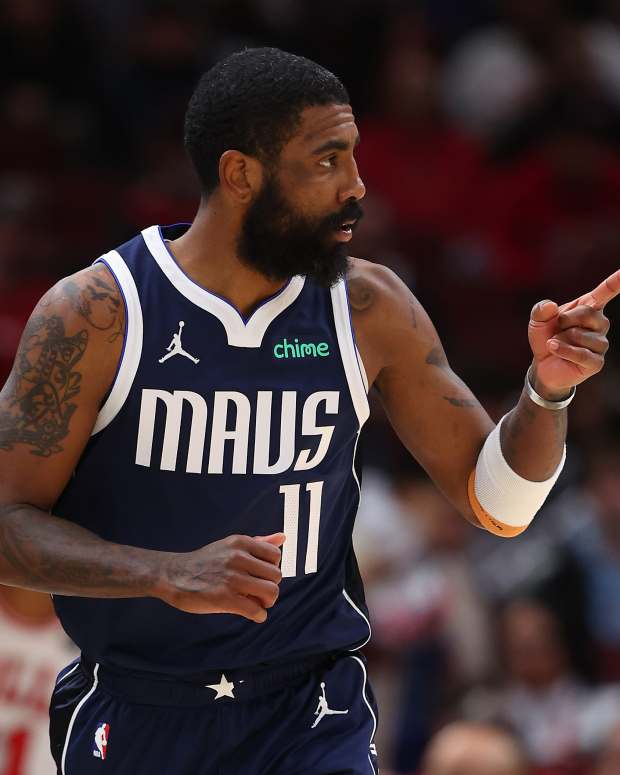 Dallas Mavericks point guard Kyrie Irving points to a teammate after hitting a three-point shot.