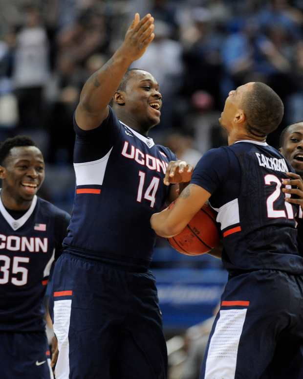 Connecticut's Amida Briham (35), Rakim Lubin (14) and Terrence Samuel (3) rush onto the court to greet Omar Calhoun (21) at the end of a 47-42 victory against Tulsa in the semifinals of the AAC Tournament at the XL Center in Hartford, Conn., on Saturday, March 14, 2015. (John Woike/Tribune News Service via Getty Images via Getty Images)
