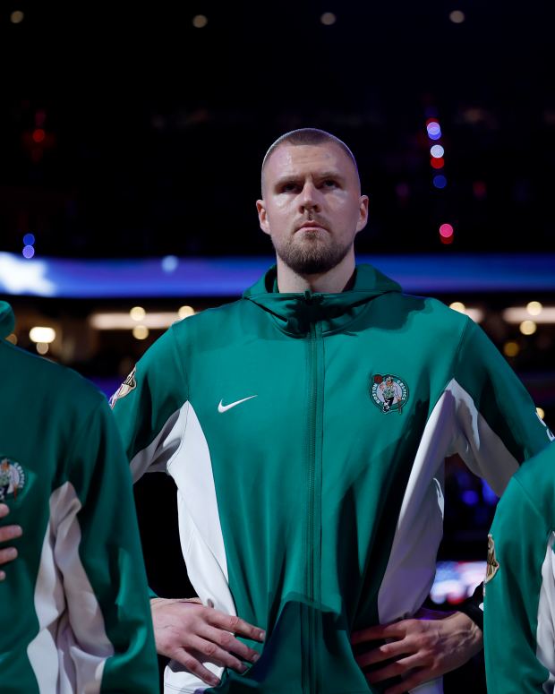 Boston, MA - June 9: Boston Celtics center Kristaps Porzingis, middle, stands during the national anthem with forward Sam Hauser, left, and guard Jrue Holiday before Game 2 of the 2024 NBA Finals. (Photo by Danielle Parhizkaran/The Boston Globe via Getty Images)