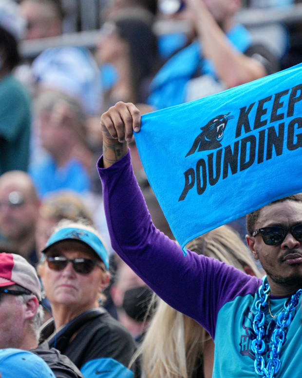 A Carolina Panthers fans holds up a "Keep Pounding" towel.